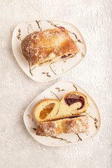 Homemade sweet bun with apricot jam on gray concrete. top view.