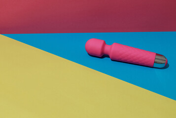 Pink dildo vibrator for satisfaction on colored background with shadows. Sex toy for adult - obrazy, fototapety, plakaty
