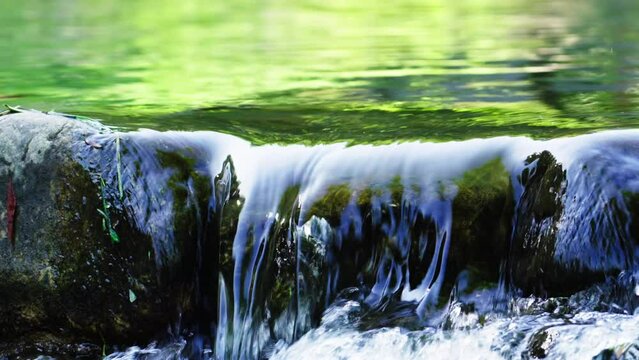 Clear and transparent spring water flows on the rocks