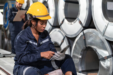 Portrait African American engineer woman use tablet working and checking metal sheet at factory	