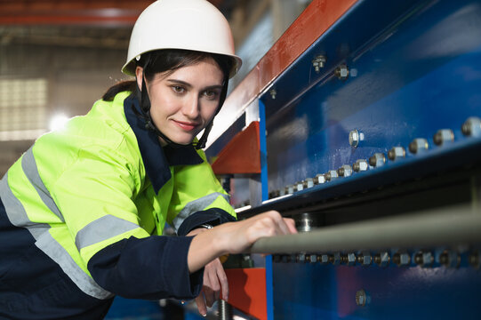 Portrait Asia engineer woman checking machine at metal sheet factory	