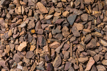 Closeup Image of Background Made of Pile of Colorful Brown, Yellow and Red Crushed Stones.