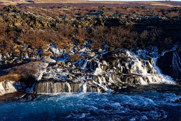 cascade islandaise gelée par le froid avec une eau turquoise et dont l'eau sort directement de la...