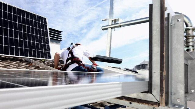 workers on the roof of a house installing solar panels -renewable energy-