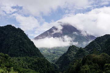 View of Mount Merapi in the morning, and slightly covered by clouds. Potentially eruptive volcano.