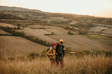 A mid adult father walking and talking with his teenage son in an autumn field, exploring and having fun.