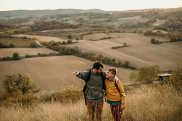 Happy family: father and teenage son talking and having fun on a nature hike at sunset. People and landscape concept