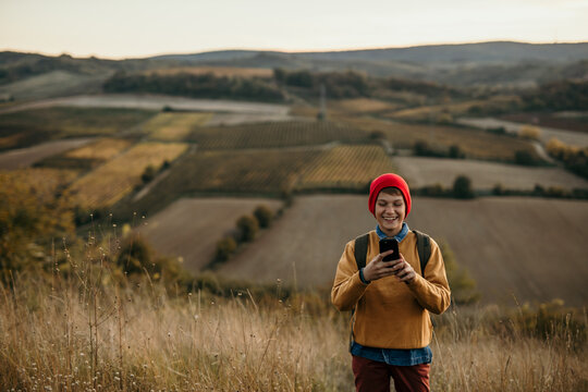 Teenager Hike And Use Cell Phone Outdoors. Boy Looking For Mobile Signal