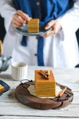 thousand layer cake on the table. hand in frame concept