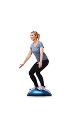 Her daily workout. A beautiful young woman standing on a bosu-ball while working out.