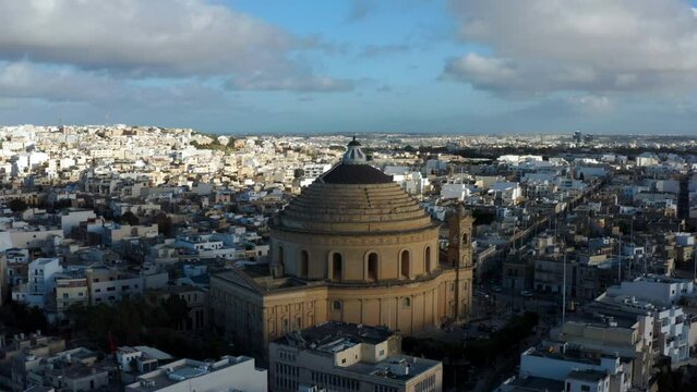 Domed 17th-century Catholic Church With Neoclassical Architecture In Rotunda Square, Mosta, Malta. Aerial Wide Shot
