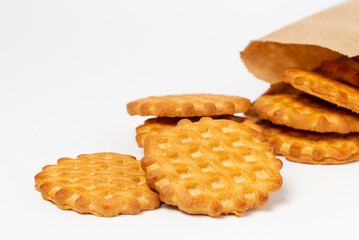 Shortbread cookies or waffles spilling out of the kraft paper bag  white background close up
