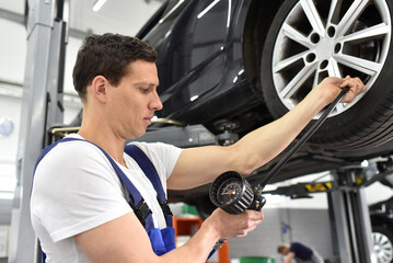 Fototapeta na wymiar auto mechanic checks the air pressure of a tire in the garage