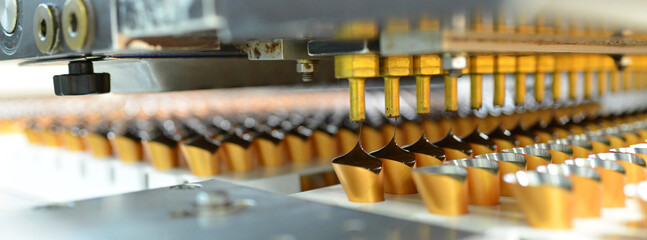 Production of pralines in a factory for the food industry - automatic conveyor belt with chocolate - 581354260