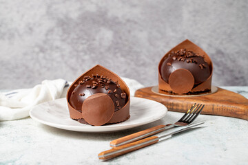 Chocolate small cake. Bakery desserts. Delicious round portion cake with cream and dragee filling