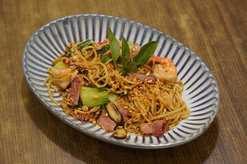 top view green leaf on shrimp and bacon spaghetti vegetables and mushrooms in a blue and white dish on wooden table background, food, eat, banner, template