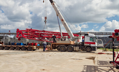 Unloading sections of the boom of a large crawler crane using a crane