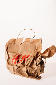 Paris, France. - January 16, 2023: Crumpled Brown Shopping H m Paper Bag Isolated On White. Used Craft Paper Shopping Bag. Recycled Paper Grocery Bag. Concept Of Shopping And Recycling.
