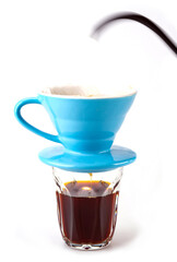 dripping coffee in soft blue color drip cup and the coffee water flows into the clear coffee cup below , isolated on white background