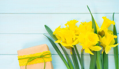Bouquet of daffodils flowers and a box with a gift