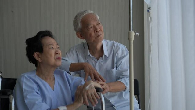 Stress worry old Asian couple have conversation while sick on wheelchair in hospital