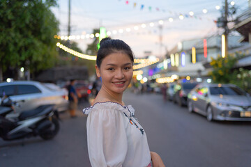 Portrait of happy Asian woman travel at night Market people walking street fair, Colorful tents in the train of Ratchada at Bangkok city, Thailand. Retail shops