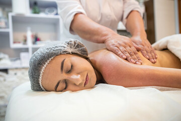 beauty client receives physical therapy from masseuse on shoulders and back in beauty spa. - obrazy, fototapety, plakaty