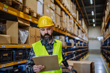 Male warehouse worker dragging a pallet truck.