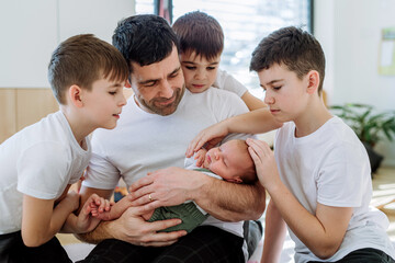 Portrait of father and his four sons, holding his newborn baby.