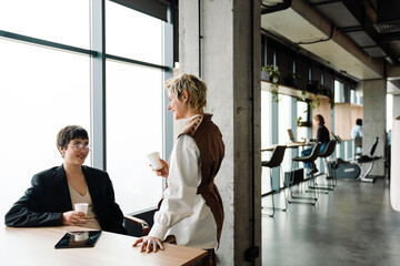 Two businesswomen discussing project during meeting in modern office space