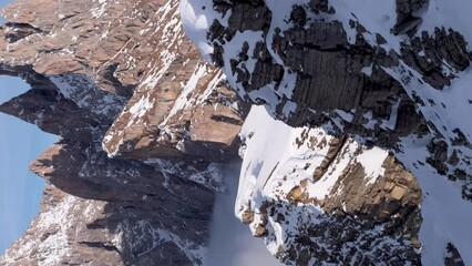 A vertical upward pan reveals the snow-capped mountain peaks of Seceda Dolomites in Ortisei during winter.