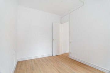 Empty white room with wooden laminate flooring and an open door in new apartment. Concept of preparing the premises for housewarming party and carrying out cosmetic repairs. Copyspace