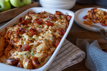 Salmon pasta casserole with tomato cream sauce, penne and cheese topping