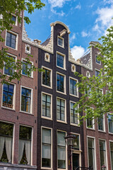 Fototapeta premium Amsterdam street in summer with colorful houses in classic holland architecture