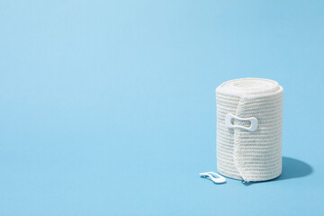 Concept of help during an injury, elastic bandage on blue background