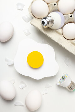 Eggs and bulbs on white background, top view