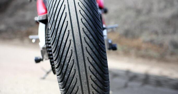 Bald smooth bad rubber motorcycle tire on road