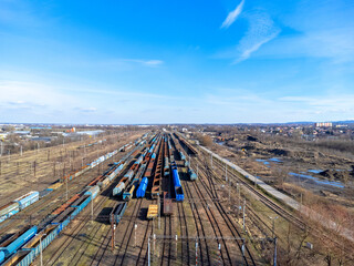 Aerial view landscape. View of railroad tracks and trains, cars, cargo. Blue sky.