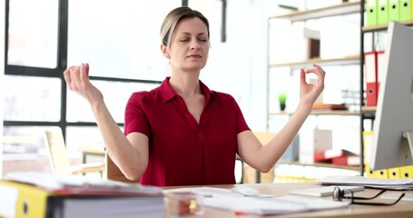 Woman manager practicing meditation at office desk at computer