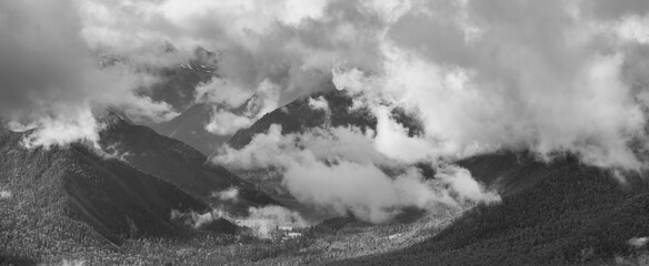 Fototapeta na wymiar Mountain peaks in the clouds, black and white landscape