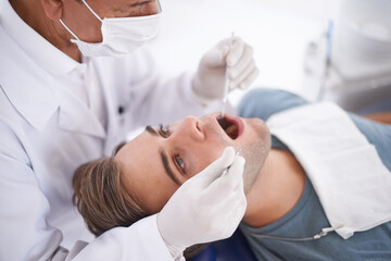 At the dentist for his bi-annual checkup. a young man at the dentist.