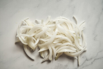 Julienne cuted onions on white marble background. Photo show how does julienne sliced or pole to...