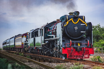 Fototapeta na wymiar Steam locomotive with passenger train passed the railway bridge.