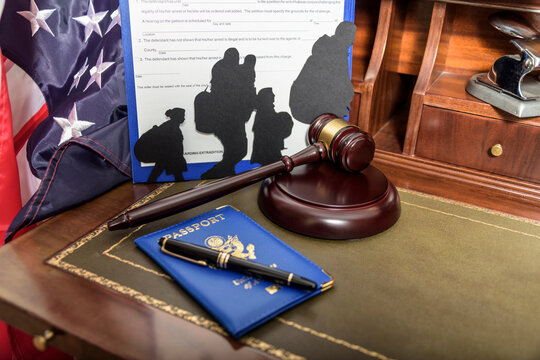 Immigration law concept. Gavel, passport and Silhouette of immigrants on wooden table.