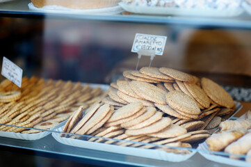 Amaretto biscuits on a showcase. Assorted sweets, cakes and cookies on display in dessert store in Pitigliano, Italy