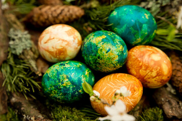 Obraz na płótnie Canvas Easter. a Christian religious holiday. painted eggs in in the composition of spruce, pine cones and cherry blossoms. tradition to variegate with various colors and various techniques. Spring fest 