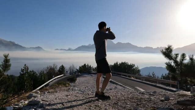 Asian traveller man taking photo of Bulkans mountain peaks in Albania.