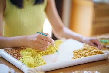 Punch needle. Asian Woman making handmade Hobby knitting in studio workshop. designer workplace Handmade craft project DIY embroidery concept.
