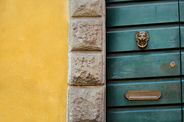 Yellow wall and green door in Manarola, one of the five centuries-old villages of Cinque Terre, Liguria, Italy.