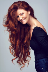 Life isnt perfect but at least my hair is. Studio shot of a young woman with beautiful red hair posing against a gray background.